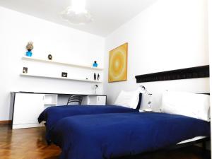 ヴェネツィアにあるSAN MARCO CITY CENTER Nouvelle Vague Apartmentの白い壁のベッドルーム1室(青いベッド1台付)