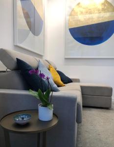 a living room with a gray couch and a table at Lily Apartment Napoli in Naples