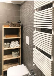 La salle de bains est pourvue de toilettes et d'une étagère avec des serviettes. dans l'établissement Lily Apartment Napoli, à Naples