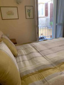 een slaapkamer met een groot bed en een raam bij Casa De Pellegrin Bellagio Lake Como in Bellagio