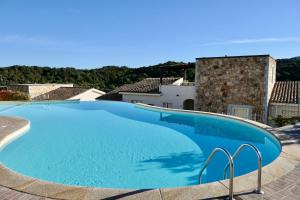 duży basen z niebieską wodą w willi w obiekcie Residence con piscina a 4 km da Baja Sardinia w mieście Cala Bitta