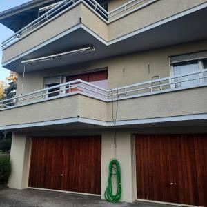 a house with a green hose hanging off the side of it at Business traveller's dream apartment in Bevaix