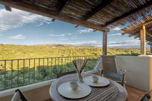 d'une table et de chaises sur un balcon avec vue. dans l'établissement Residence con piscina a 4 km da Baja Sardinia, à Cala Bitta