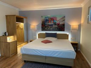 Hotel Hessischer Hof في بوتسباخ: غرفة نوم بسرير ودهان على الحائط