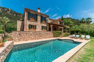 a villa with a swimming pool in front of a house at Cas Galgo luxury Villa in Valldemossa in Valldemossa