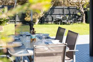una mesa con vasos y platos encima en Dromana Beach Holiday House *3 minutes to the sand, en Safety Beach