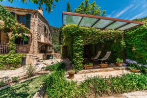 an outdoor patio with a pergola and plants at Cas Galgo luxury Villa in Valldemossa in Valldemossa