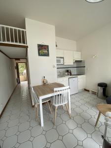 - une cuisine avec une table et des chaises dans la chambre dans l'établissement Appartement vue mer île d'Oléron, à Saint-Trojan-les-Bains