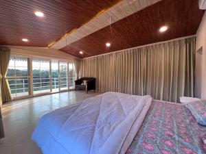 ein Schlafzimmer mit einem großen Bett und einem großen Fenster in der Unterkunft The Riverside Estate - 2Bedroom Private Pool Villa in Udaipur in Udaipur