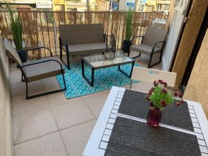 un patio con sillas, una mesa y un jarrón en Beau T2 clim terrasse idéalement situé en Aix-en-Provence