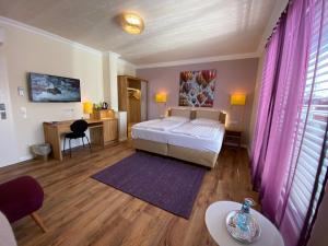 1 dormitorio con cama, mesa y escritorio en Hotel Hessischer Hof en Butzbach
