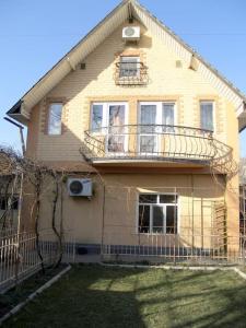 a yellow house with a balcony on top of it at Дом для большой и дружной семьи in Bishkek