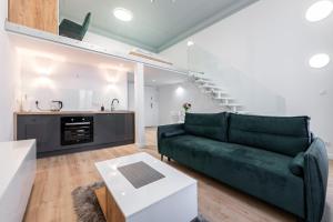 un soggiorno con divano verde e una cucina di Apartamenty Centrum nowoczesny design - Dream Apart a Bielsko-Biała