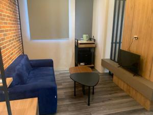 a living room with a blue couch and a table at Dormus CoLiving in Bandung