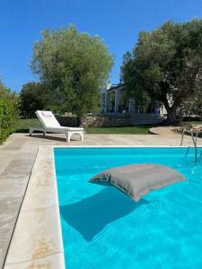 ein Kissen in der Mitte eines blauen Pools in der Unterkunft Villa Agosto, luxe villa met zwembad en zeezicht in Puglia in Carovigno