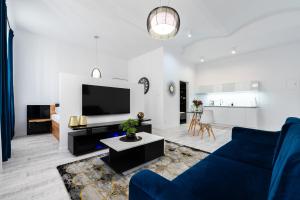 a living room with a blue couch and a tv at Apartamenty Centrum nowoczesny design - Dream Apart in Bielsko-Biala