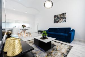 a living room with a blue couch and a table at Apartamenty Centrum nowoczesny design - Dream Apart in Bielsko-Biala +105 photos