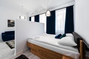 a bedroom with a large bed with blue curtains at Apartamenty Centrum nowoczesny design - Dream Apart in Bielsko-Biala