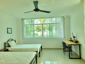 - une chambre avec 2 lits et un ventilateur de plafond dans l'établissement Yana House Phnom Penh, à Phnom Penh