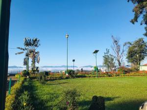 un parque con césped verde, árboles y luz de la calle en La Paz Coorg homestay at Madikeri town, en Madikeri