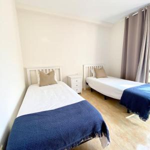 a bedroom with two beds with blue and white sheets at The best Views - La Gomera in San Sebastián de la Gomera +9 photos