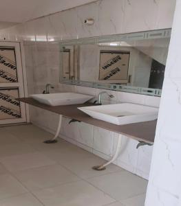 a bathroom with two sinks and a mirror at Jiya Green Garden & Banquet, Sonipat in Sonīpat