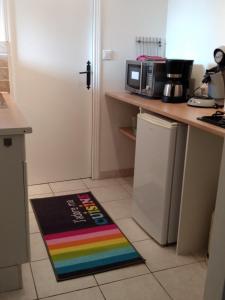 a rainbow rug on a kitchen floor next to a refrigerator at L'Auberge in Abjat