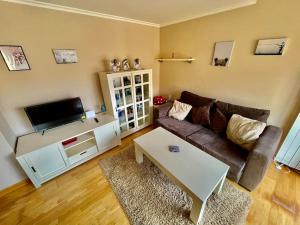 Una sala de estar con un sofá y un televisor. en Banksy Love, en Reinosa