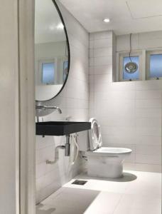 een badkamer met een wastafel, een toilet en een spiegel bij 80 Colonie (4 Pax) in Bukit Fraser