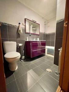 baño con lavabo púrpura y aseo en Banksy Love, en Reinosa