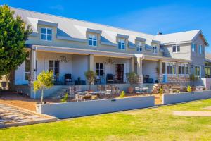 a large white house with a yard at Anchorage River House in Stilbaai