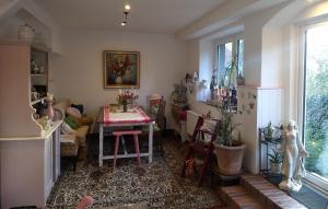 a dining room with a table and a room with a window at Das Gartenhaus in Neudorf