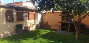 a yard in front of a house with a tree at Suite Felix in Fiumicino