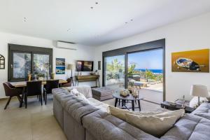 a living room with a large couch and a table at Villa Politimi Luxury Retreat in Skopelos Town