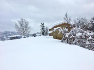 a house covered in snow in front at Agriturismo Fonte Rosa in Fiastra