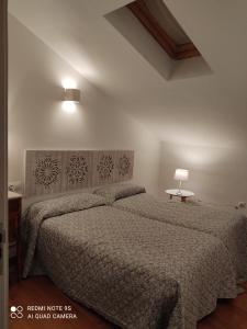 a bedroom with a large bed and a lamp at Ático Torre Candelaria in Zafra