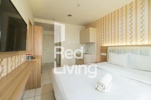 1 dormitorio con 1 cama blanca grande y TV en RedLiving Apartemen Sentul Tower - Skyland en Bogor