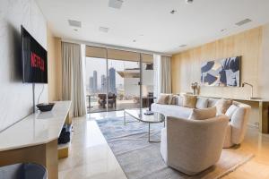 a living room with a couch and a table at Beautiful 2BR High-Floor Marina View in Five in Dubai
