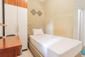 a small bedroom with a bed and a desk at Koolkost near Stikes Cirebon in Cirebon