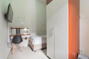 Schlafzimmer mit einem Bett, einem Schreibtisch und einem Stuhl in der Unterkunft Koolkost near Stikes Cirebon in Cirebon