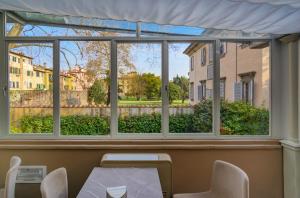 - une fenêtre dans une chambre avec une table et des chaises dans l'établissement Hotel Ilaria, à Lucques