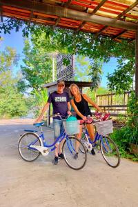 a man and a woman standing next to their bikes at Baan Suan Leelawadee Resort Nan in Nan