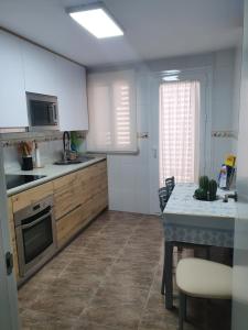 a kitchen with white cabinets and a table and a counter at Piso Acuario in Puerto de Mazarrón