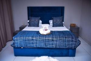 a blue bed with a teddy bear sitting on it at La mbeu concierge in Thohoyandou
