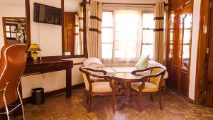 a living room with a table and chairs and a television at Happy Rhino Lodge in Arusha