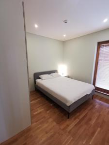 um quarto com uma cama e piso em madeira em Vytauto 422 Apartments by JK em Palanga