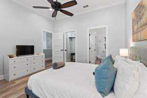 a white bedroom with a bed and a ceiling fan at Stonewall House in St. Augustine