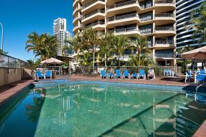 una piscina con sedie e un edificio di Voyager Resort a Gold Coast