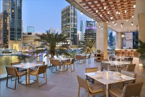 a restaurant with tables and chairs and a view of the city at InterContinental Dubai Marina by IHG in Dubai