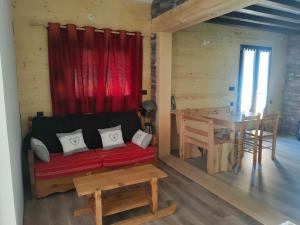 a living room with a red couch and a table at La tanière du lac d Aiguebelette in Lepin-le-Lac +16 photos